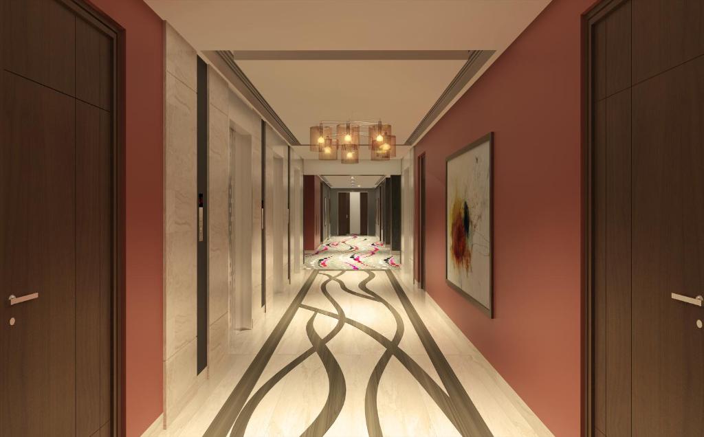 a hallway with orange walls and a hallway with shadows on the floor at Flora Al Barsha Hotel At The Mall in Dubai