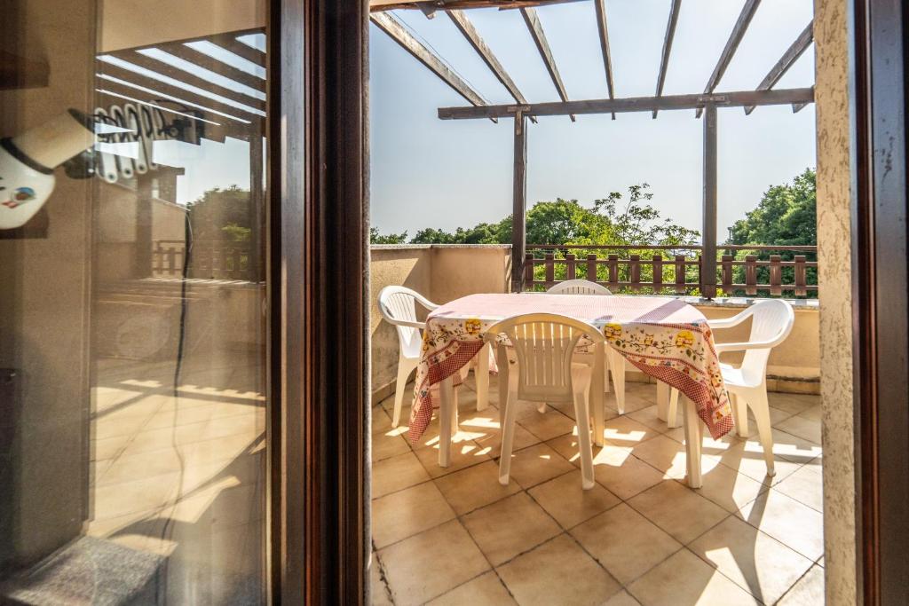 a patio with a table and chairs on a balcony at Visogliano Roomy Apt w/ Terrace near the Station in Sistiana