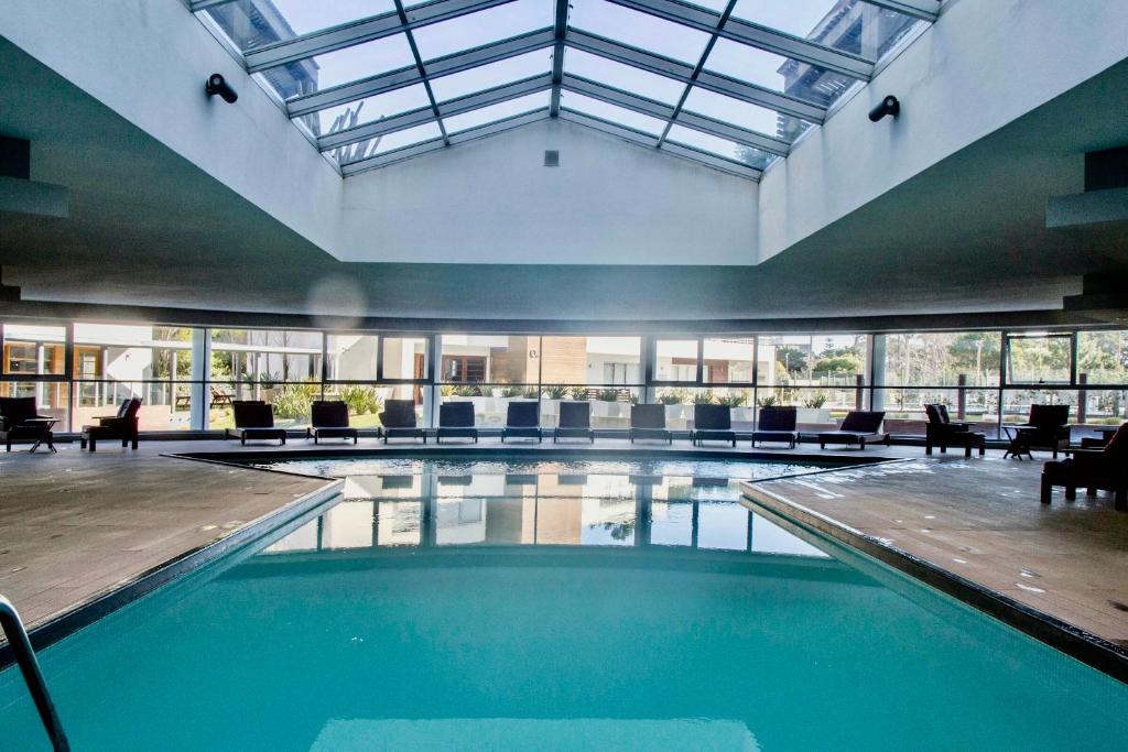 una gran piscina cubierta con sillas y techo en Oceana Suites en Ocean Drive, con piscina interior climatizada, en Punta del Este