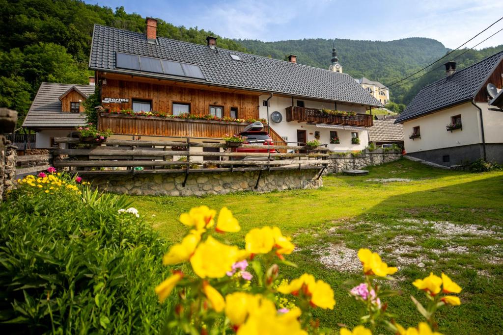 ein Haus mit Blumen davor in der Unterkunft Apartments Kocjanc in Bohinj