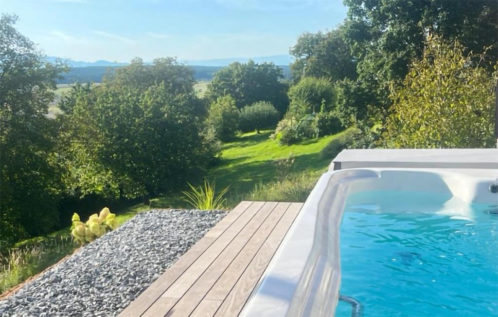 a swimming pool with a wooden deck next to a yard at Nice Home In Litzelsdorf With Outdoor Swimming Pool, Wifi And 2 Bedrooms in Litzelsdorf