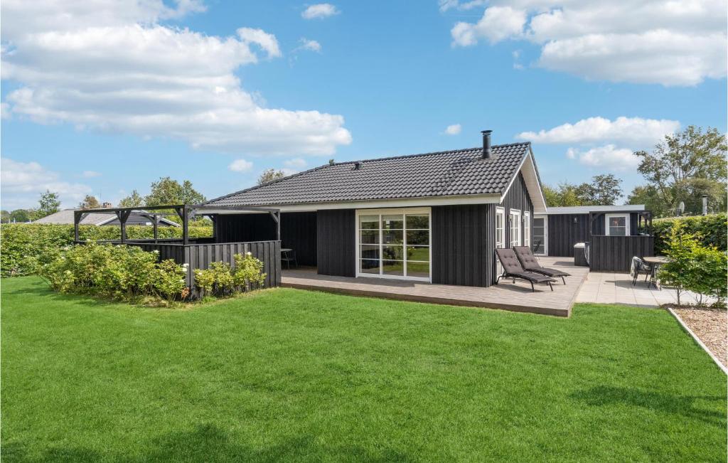 uma pequena casa preta com um jardim verde em 4 Bedroom Gorgeous Home In Hadsund em Hadsund