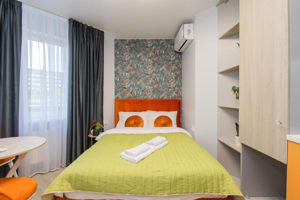 Un pequeño dormitorio con una cama verde y una mesa en MYFREEDOM Апартаменти метро Шулявська en Kiev