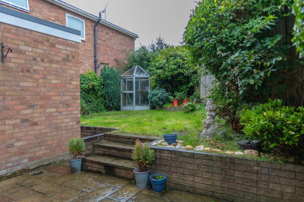 a garden with a greenhouse in the back of a house at Workers & Visitors- Gainford 4Bedrooms in Walsgrave on Sowe