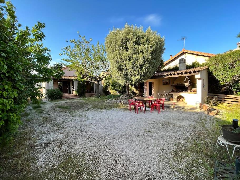 un patio con mesa y sillas frente a una casa en Agréable maison provençale avec jardin en Marsella