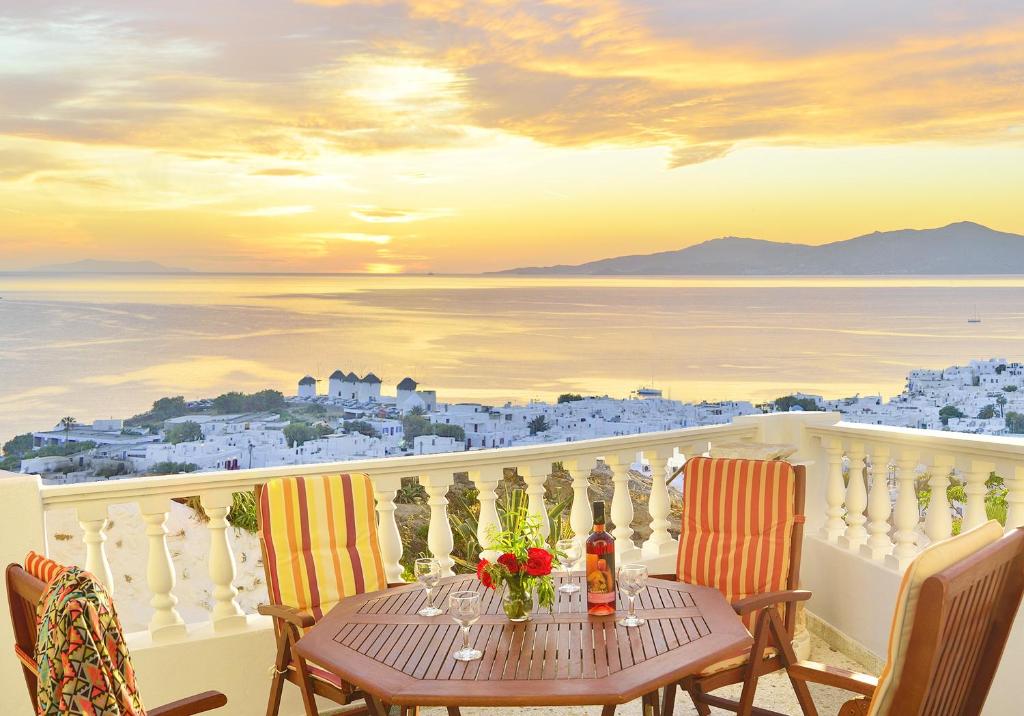 a table on a balcony with a view of the ocean at Hotel Nazos 1 in Mýkonos City