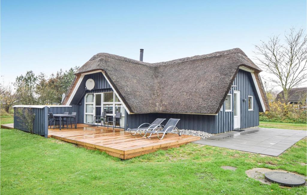 ブラーバンドにあるAmazing Home In Blvand With 4 Bedrooms, Sauna And Wifiのデッキと屋根付きの黒いコテージ