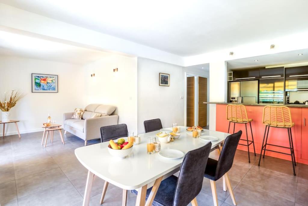 a dining room and kitchen with a white table and chairs at C9 2BDR Cannes center AC/Parking easy walk Palais&Sea in Cannes