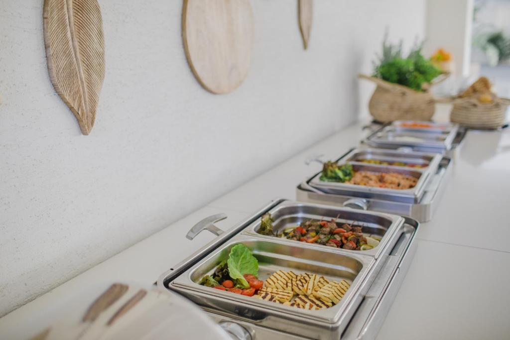 a row of trays of food on a counter at Nissi Park Hotel in Ayia Napa