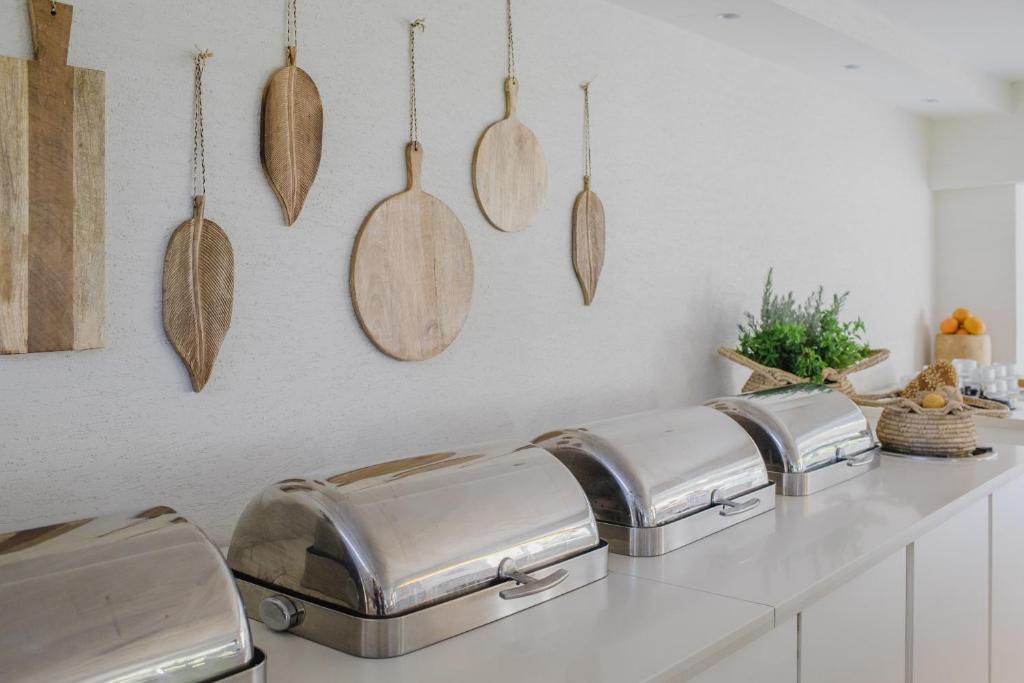 a kitchen counter with four pans and wooden utensils at Nissi Park Hotel in Ayia Napa