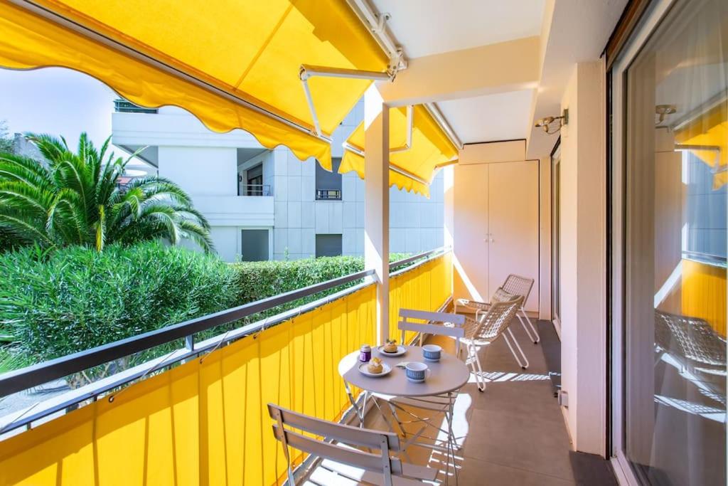 d'un balcon avec une table et des chaises sur un mur jaune. dans l'établissement C9 - 2 BDR 10 min Palais Festivals & Sea - AC, Parking & Balcony, à Cannes