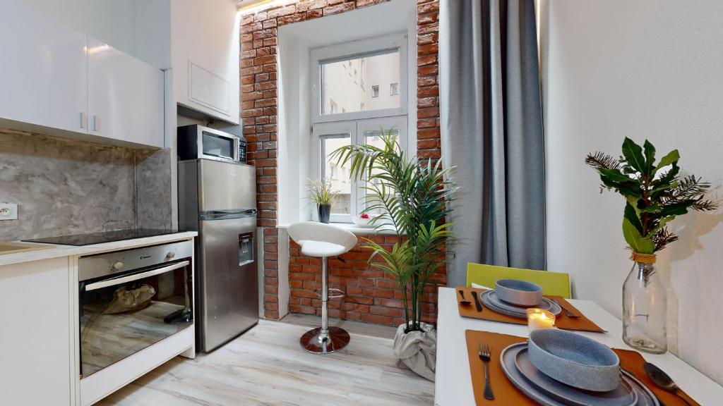 uma cozinha com uma parede de tijolos e uma mesa com pratos em New Stylish Place for Couple em Bratislava
