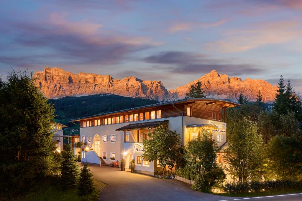 un edificio con una montaña en el fondo en Dolomit Boutique Hotel en La Villa