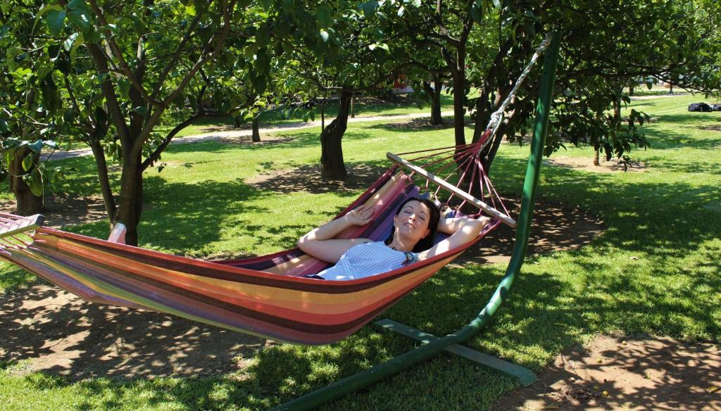 a woman laying in a hammock in a park at Le Jardin de Temeni in Aigio