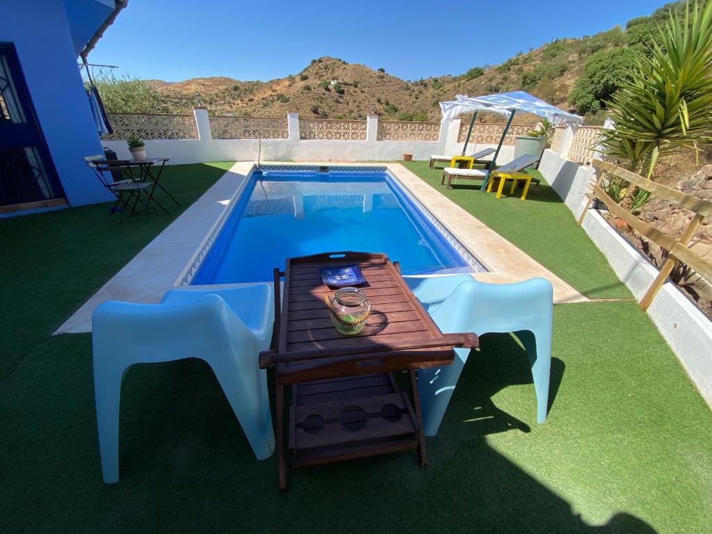 a table and chairs next to a swimming pool at Casa Rural Los Almendros in Málaga