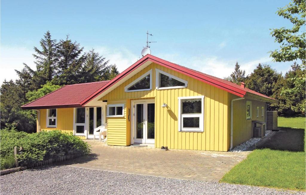 una pequeña casa amarilla con techo rojo en Nice Home In Blvand With Sauna, en Blåvand