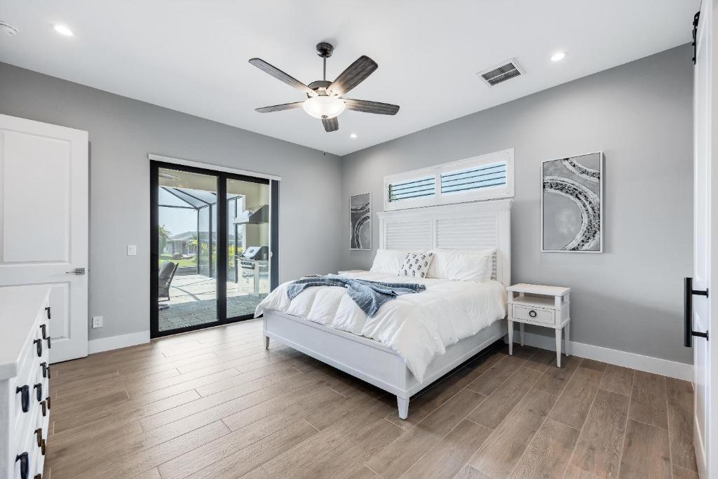 - une chambre avec un lit et un ventilateur de plafond dans l'établissement New Home, Pool, Tiki Hut, Sleeps 8 - Villa Cielo Sur, à Cape Coral