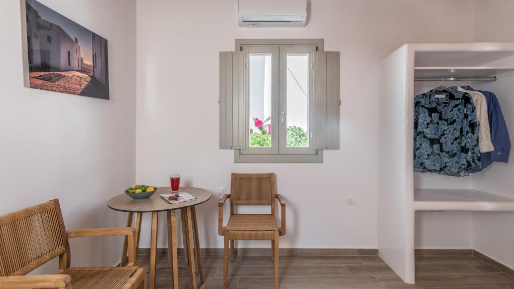 a room with a table and chairs and a window at Studios Betty in Plaka Milou