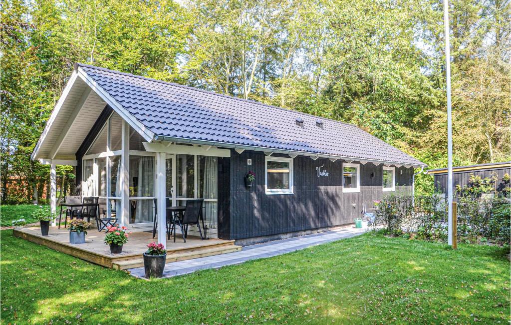 a black tiny house with a porch and a yard at 3 Bedroom Nice Home In Esbjerg V in Esbjerg