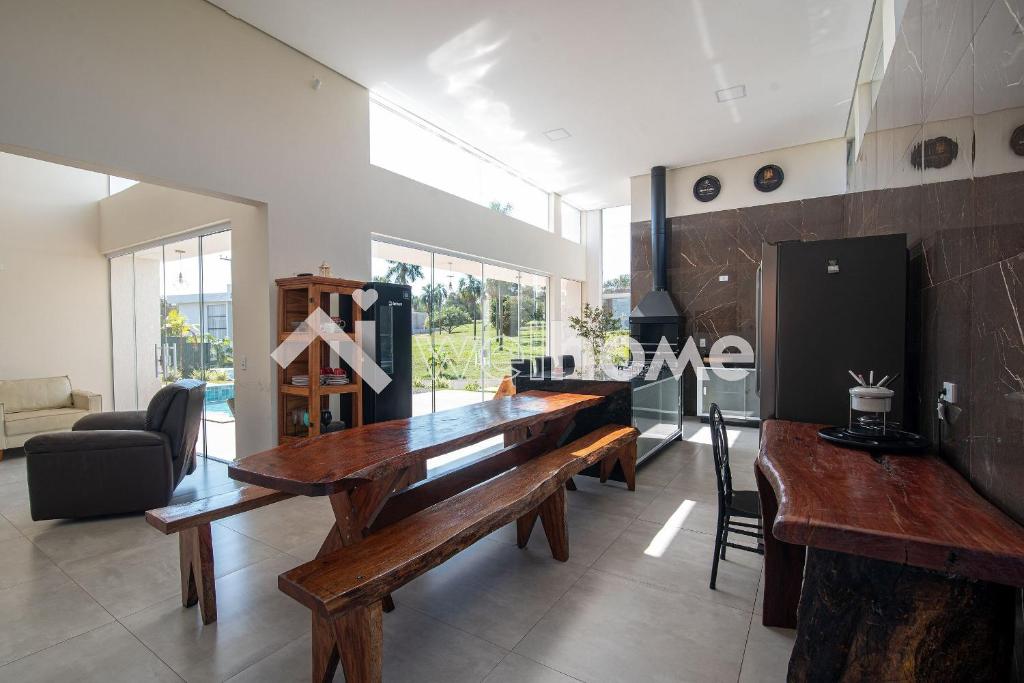 - un salon avec une table en bois et un canapé dans l'établissement Casa com 4 suítes em Riviera de Santa Cristina, à Itaí