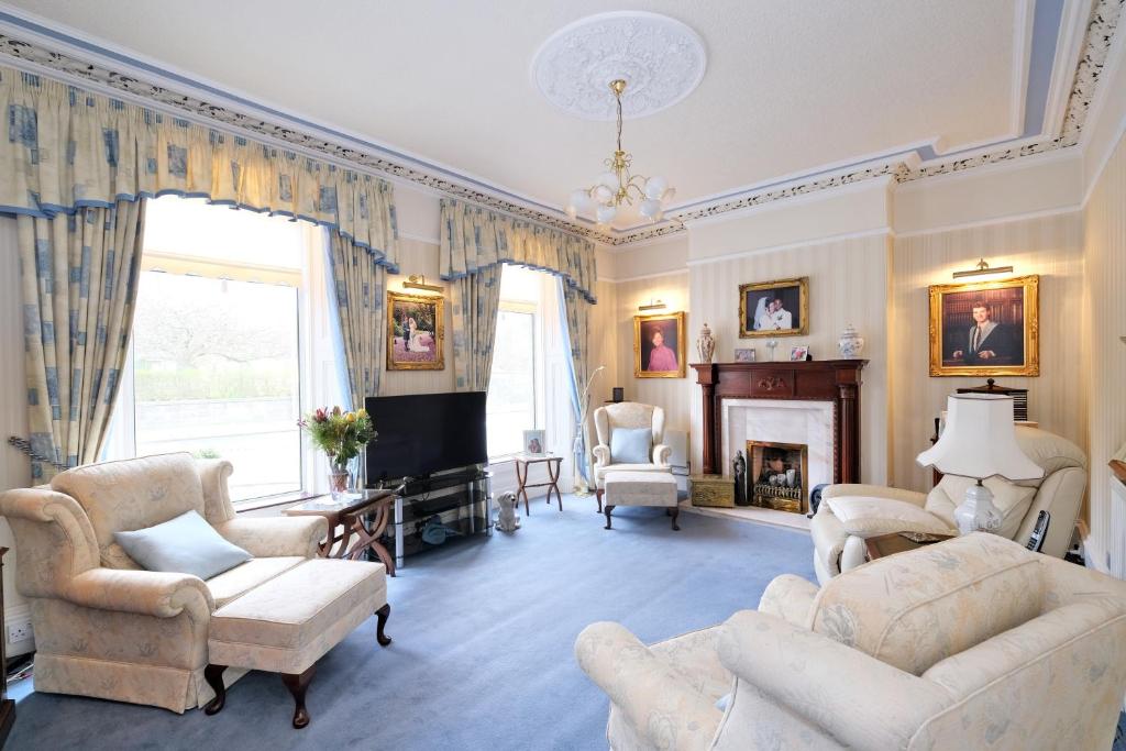 a living room with couches and a fireplace at The Jays Guest House in Aberdeen