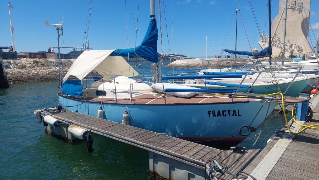 a blue boat is docked at a dock at Vintage Sailboat in Belém in Lisbon