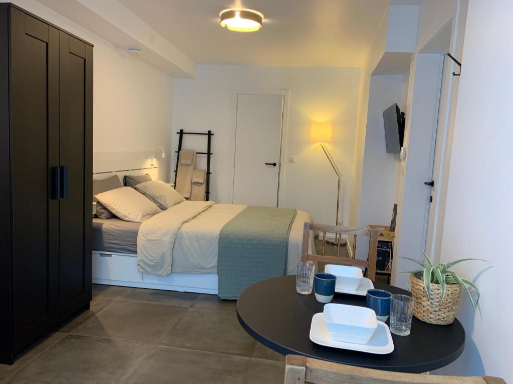 a bedroom with a bed and a table with chairs at Homestay, ground floor, comfort room in Bruges