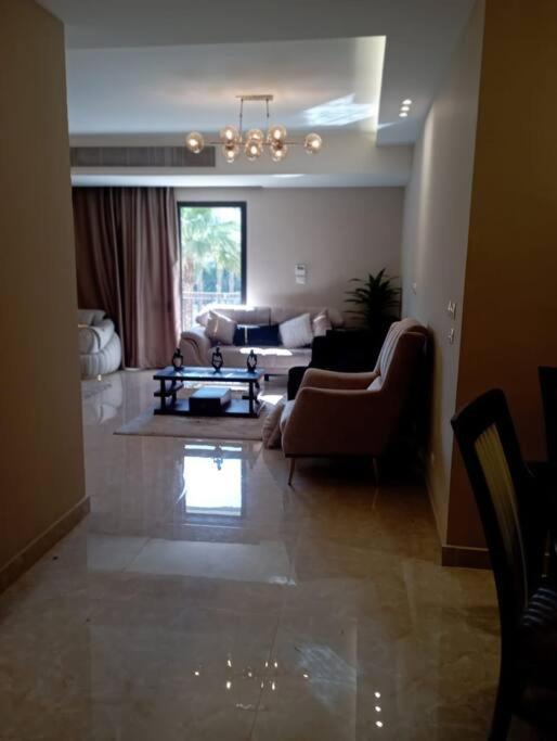 een woonkamer met een bank en een tafel. bij بيفرلي هيلز ويست تاون الشيخ زايد in Sheikh Zayed