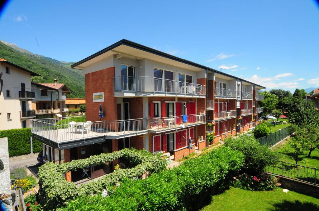 budynek z czerwonymi drzwiami i balkonami z dziedzińcem w obiekcie Residence Windsurf w mieście Domaso