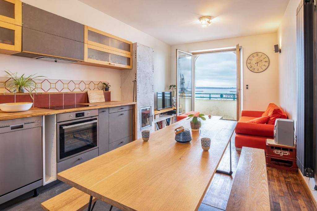 Il comprend une cuisine et un salon avec une table et un canapé. dans l'établissement Avec une belle vue sur mer, à Brest