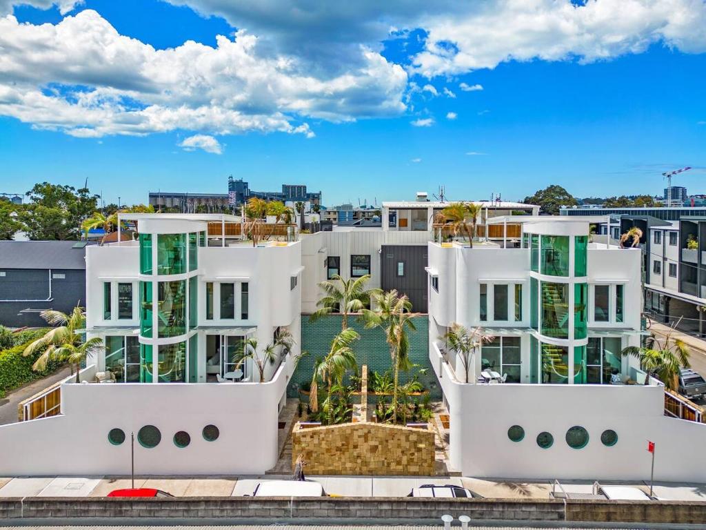 Vista árida de dos edificios blancos en una ciudad en The Urban Resort - A Mediterranean-style Group Haven across Two Homes en Wickham