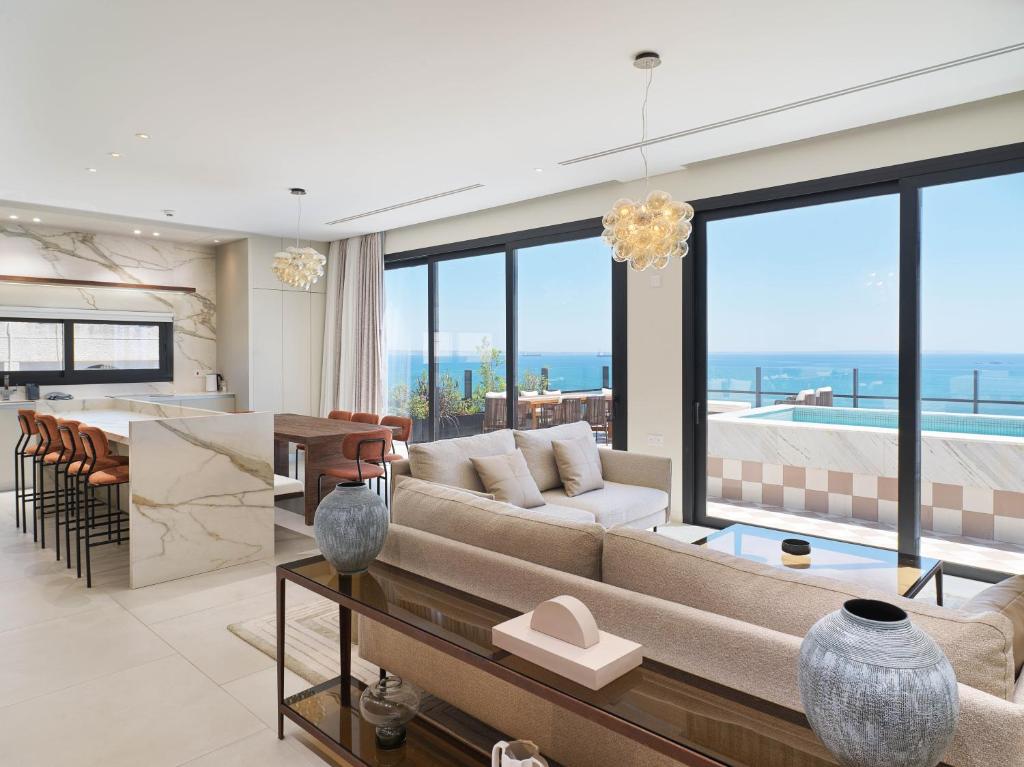 a living room with a couch and a table at LIV Mackenzie Beach Suites Larnaca in Larnaca