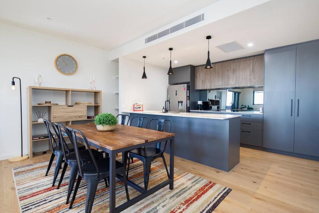 a kitchen and dining room with a wooden table and chairs at 'Highpoint Lookout' A Cool Charlestown Square Abode in Charlestown
