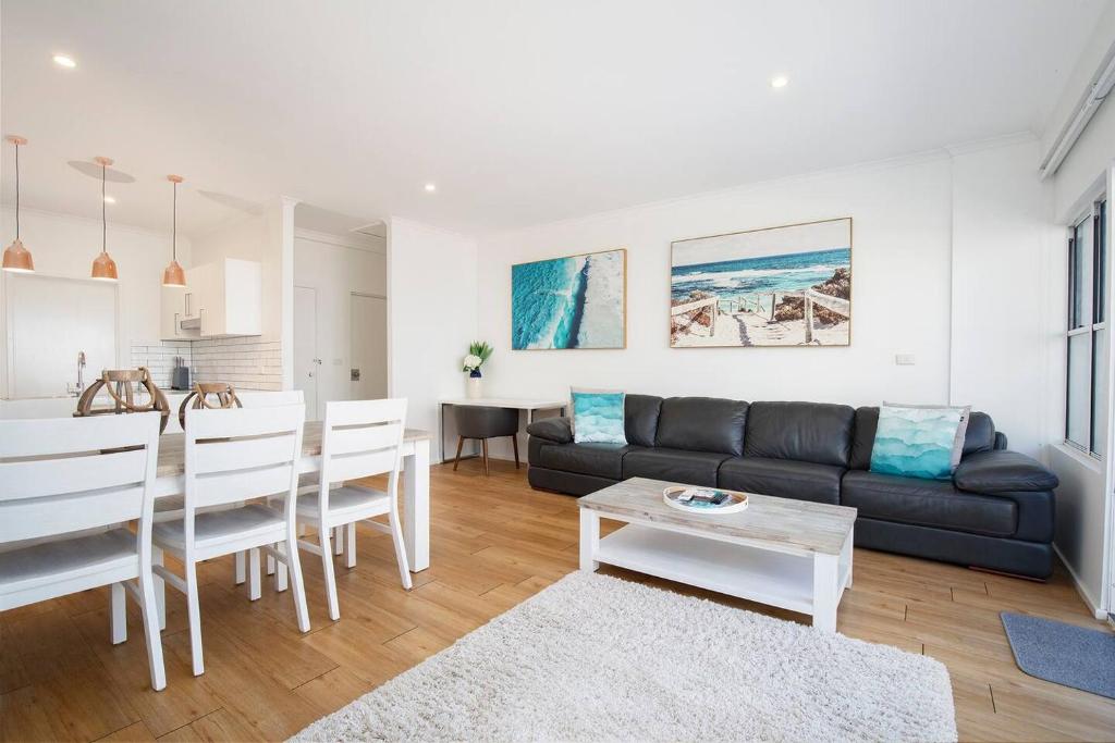 a living room with a couch and a table at 'Sandy Shores' A Spacious Newcastle Beach Escape in Newcastle