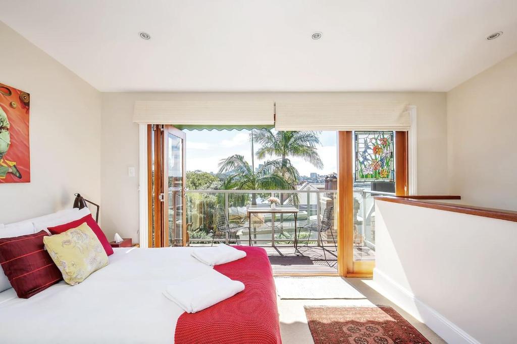 una camera da letto con divano rosso e balcone di Elegant Vintage Terrace with Harbour Bridge Views a Sydney