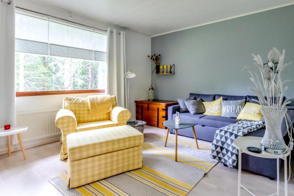 een woonkamer met een blauwe bank en stoelen bij Holiday Apartment Usva Studio C 7 in Kemijärvi