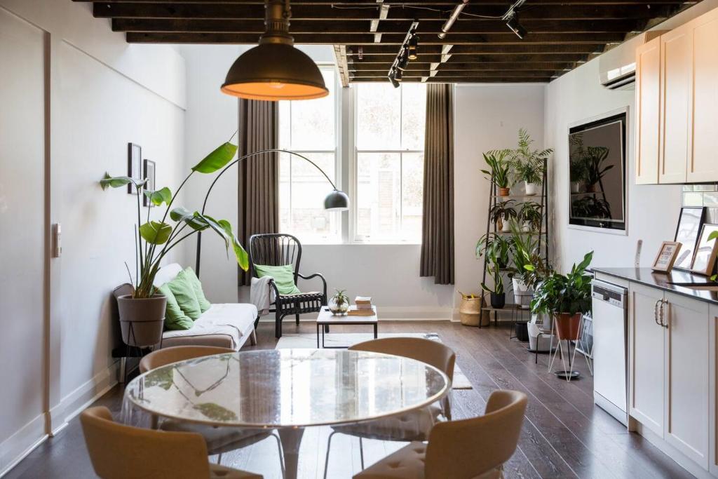 uma sala de estar com uma mesa de vidro e cadeiras em Loft-Style Living - Sophisticated Urban Retreat em Sydney