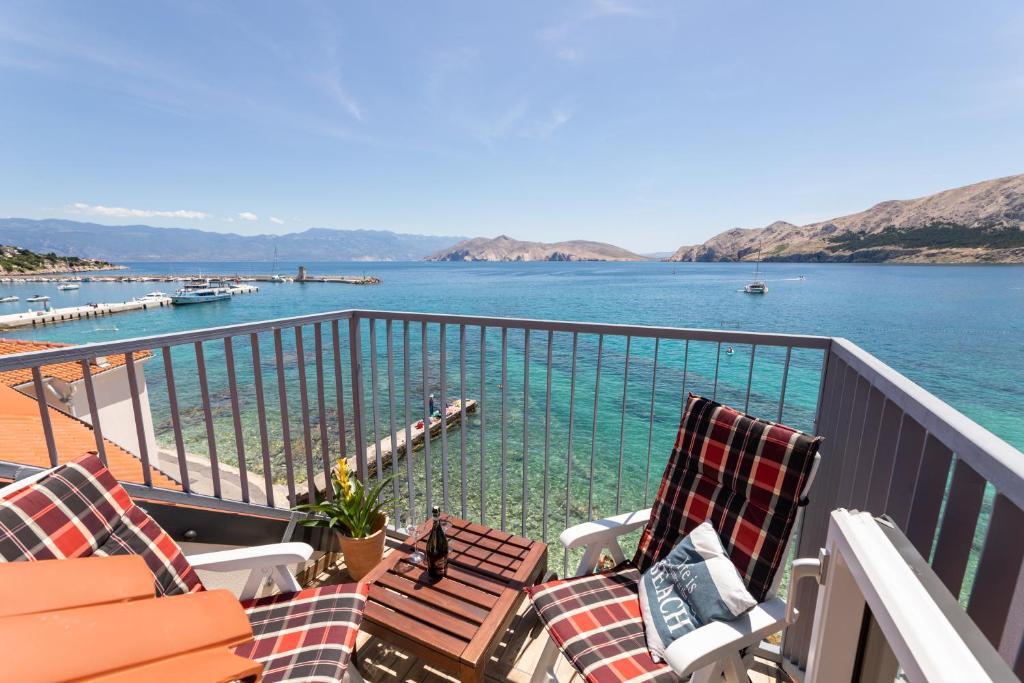 a balcony with chairs and a view of the water at Little beach house in Baška