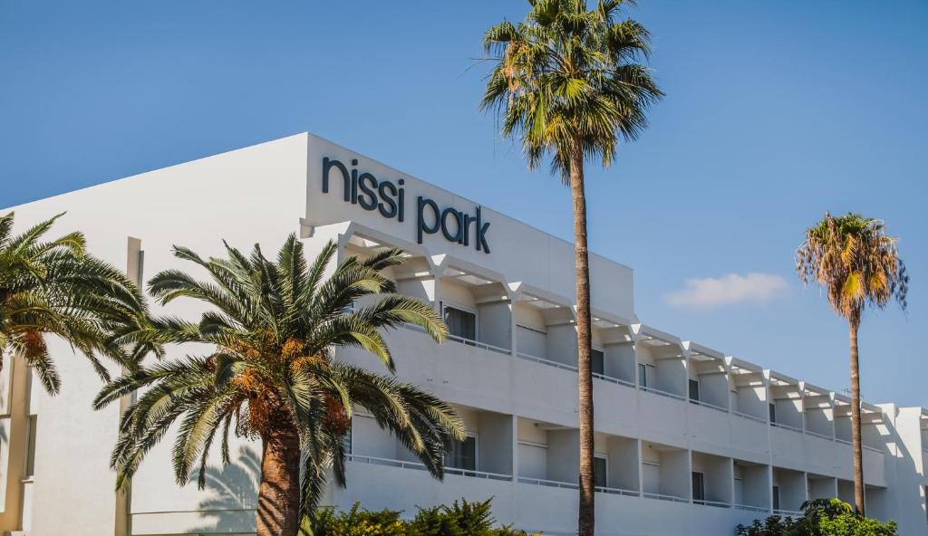 a hotel with palm trees in front of it at Nissi Park Hotel in Ayia Napa