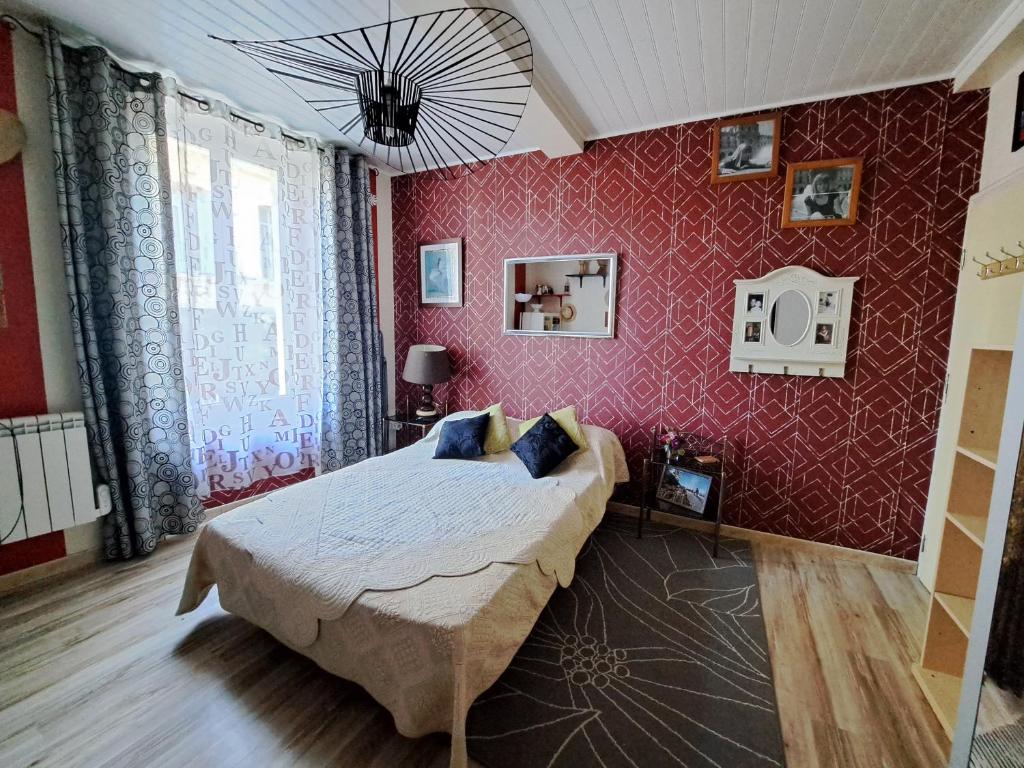 um quarto com uma cama e uma parede vermelha em Valou 136 em Cuxac-dʼAude