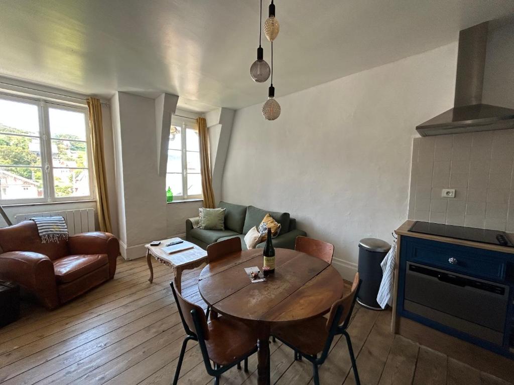 een woonkamer met een tafel en een bank bij Gîte « Le Marie » in Saint-Martin-aux-Buneaux