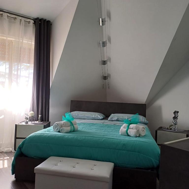 a bedroom with a bed with green sheets and towels at Casa Harmony in Leonforte