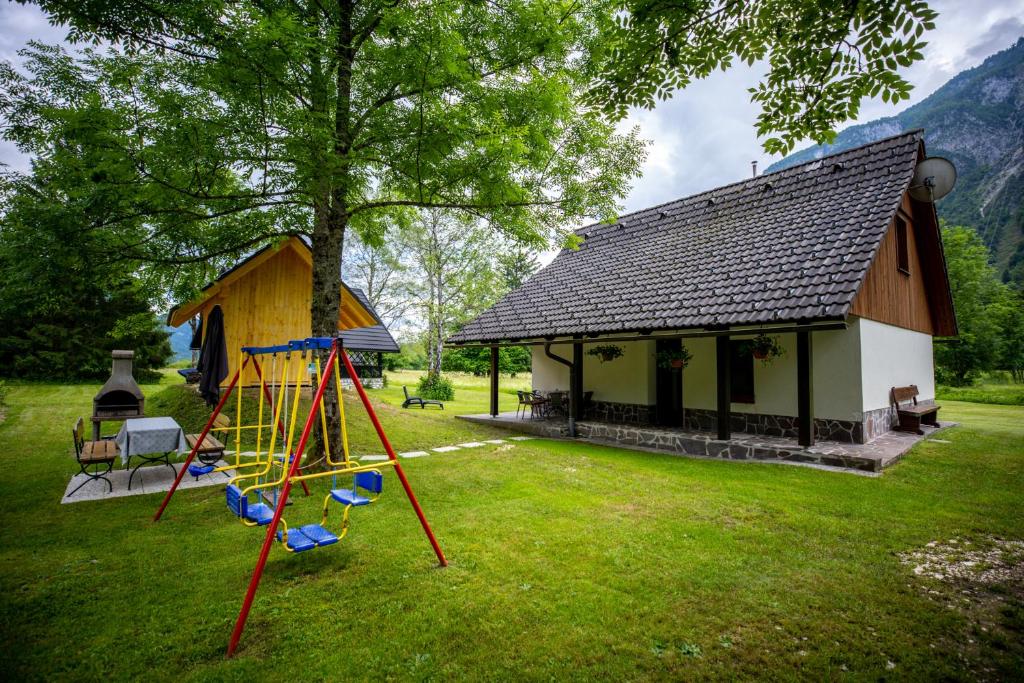 un parque infantil frente a un edificio con una casa en Počitniška hiša Taler, en Bohinj