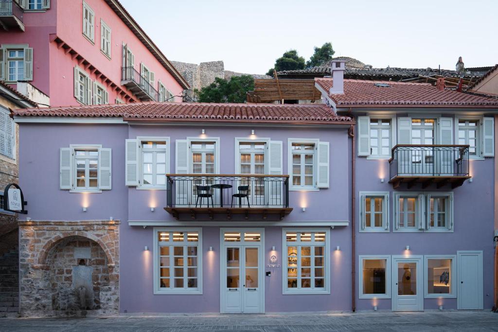 a purple building with a balcony on it at Navria by Aetoma in Nafplio