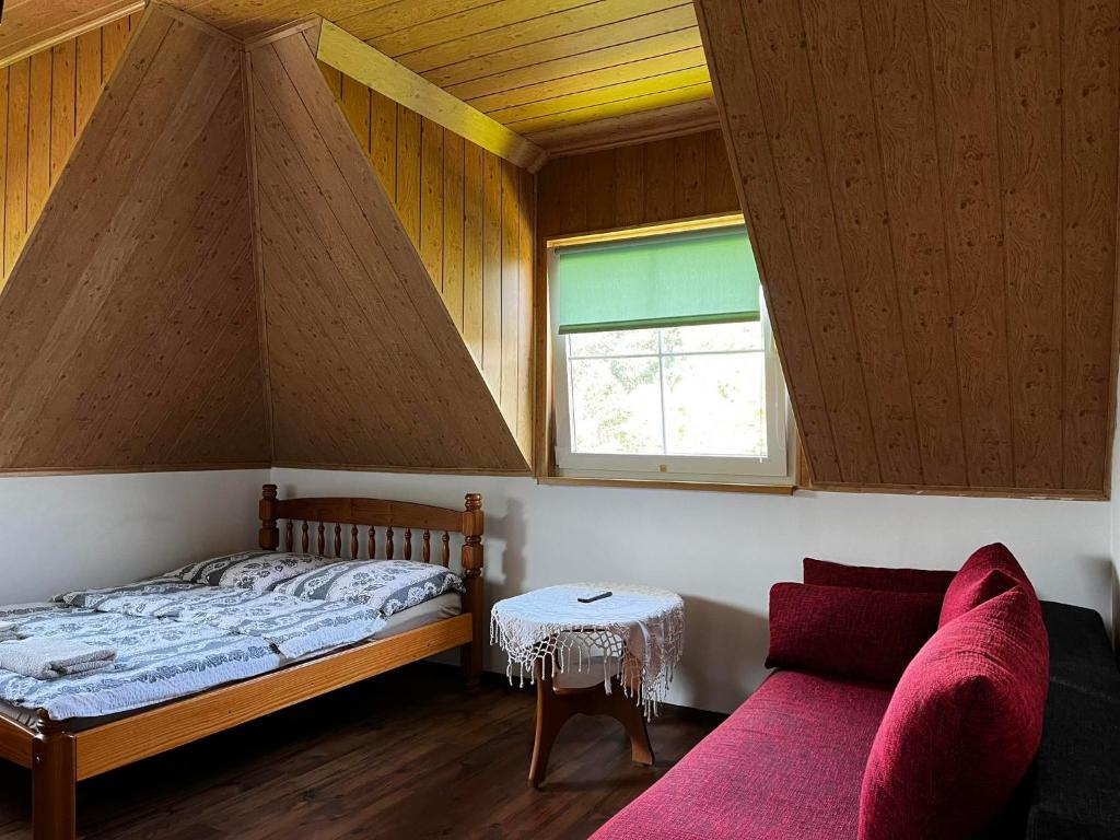 ein Schlafzimmer mit einem Bett, einem Tisch und einem Sofa in der Unterkunft Rajsko in Polańczyk