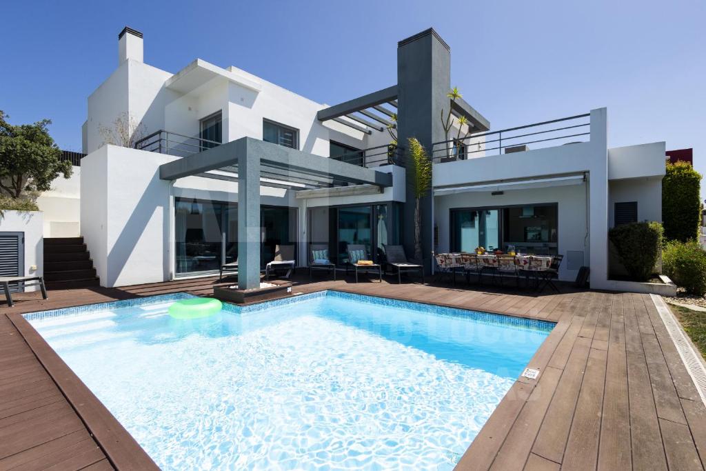 une maison avec une piscine en face de celle-ci dans l'établissement Aqua Villa by AcasaDasCasas, à Ericeira