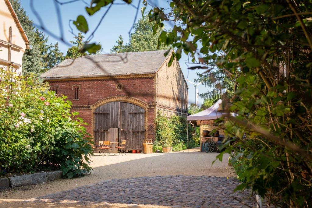 an old brick building with a large wooden door at Gut Leben Landresort in Bernau bei Berlin