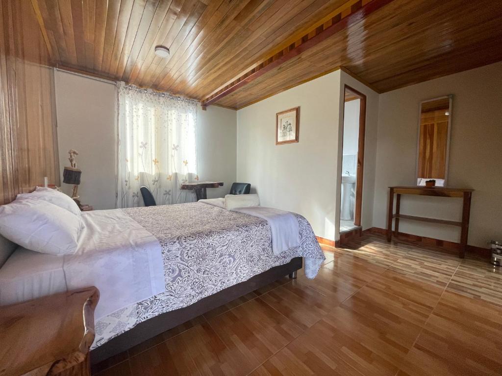 um quarto com uma cama grande e um tecto de madeira em Paz y Bien em Villa Rica