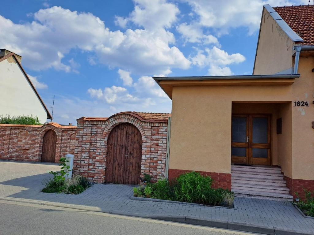 a brick building with a wooden door and two gates at Jiřinka in Vracov