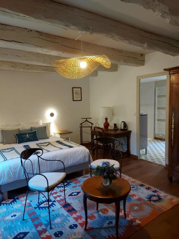 um quarto com uma cama, cadeiras e uma mesa em Manoir de l'Angélus em Dol-de-Bretagne
